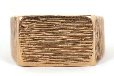 Lot 55 - A 9ct ring, with 10mm wide textured plaque...