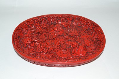 Lot 361 - A Chinese red lacquer dish with raised relief...