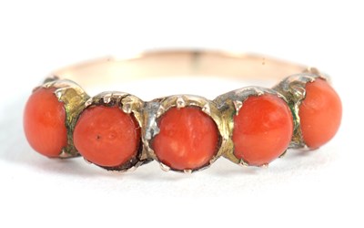 Lot 81 - A coral ring, the five round coral cabochons...