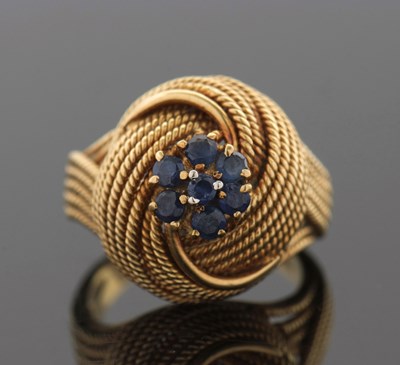 Lot 353 - A sapphire set knot ring, the flowerhead...