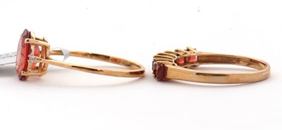 Lot 99 - Two 9ct treated orange quartz rings: to...