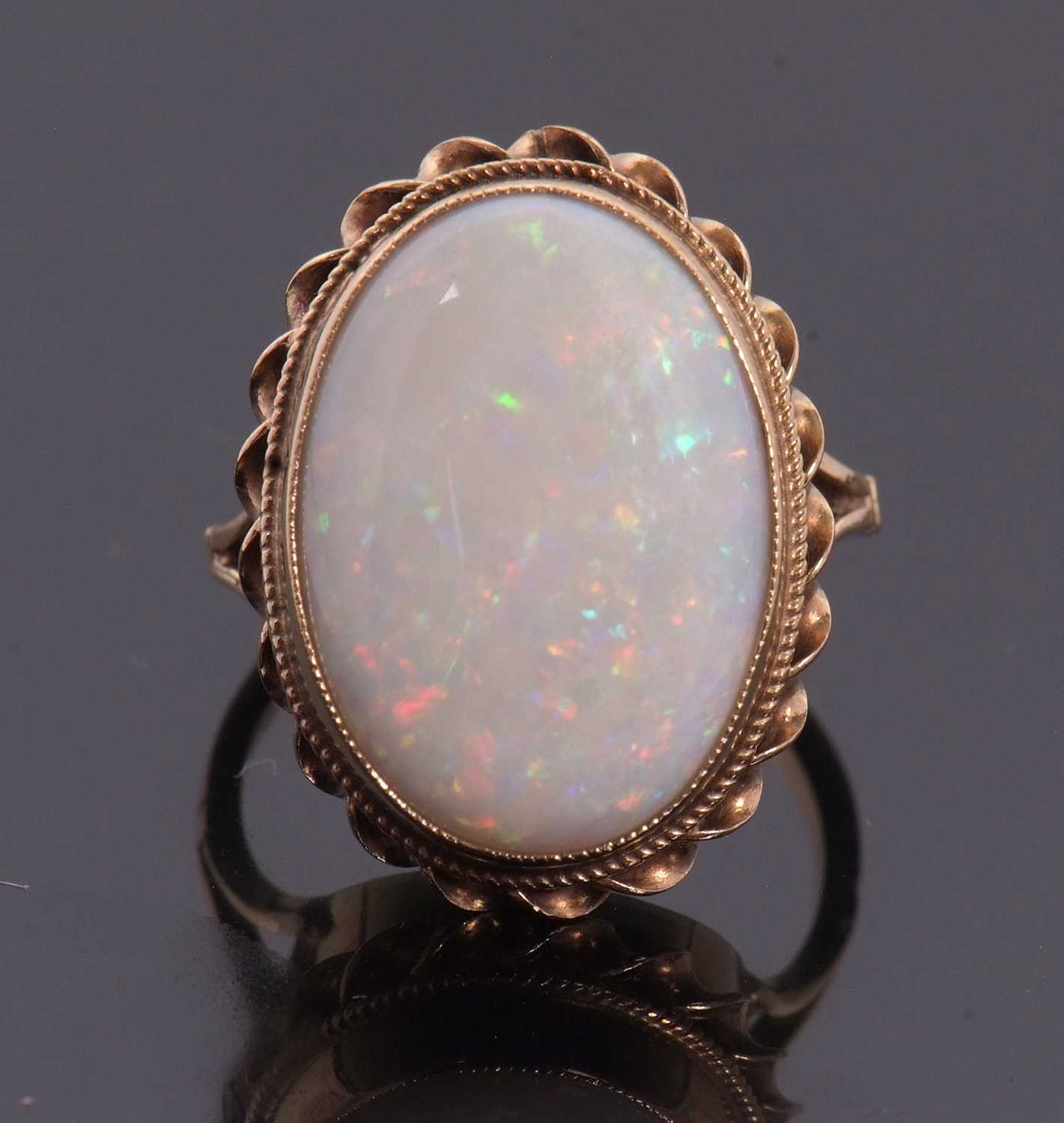 Lot 19 - A 9ct opal ring, the oval opal cabochon,...