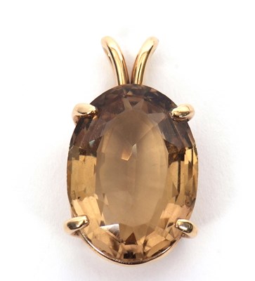 Lot 225 - A 14K quartz pendant, the oval lemony-brown...