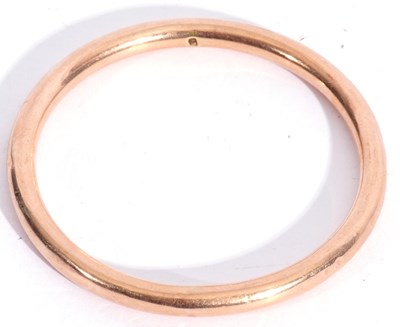 Lot 142 - Yellow metal bangle, a hollow tubular design,...