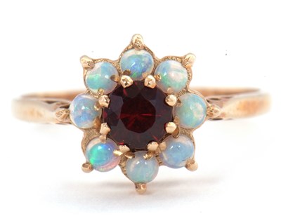Lot 67 - A 9ct opal and garnet ring, the central round...