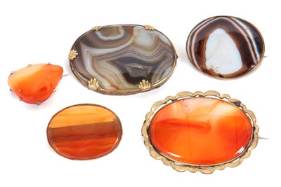 Lot 199 - Five agate brooches, to include an oval banded...