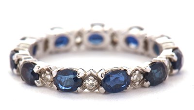 Lot 14 - A sapphire and diamond eternity ring, the full...