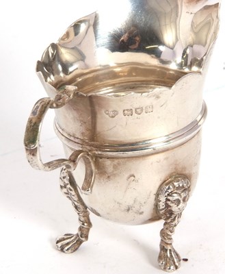 Lot 25 - A George V silver cream jug having a card cut...
