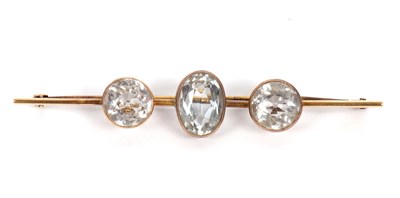 Lot 103 - A topaz bar brooch, the central oval topaz,...