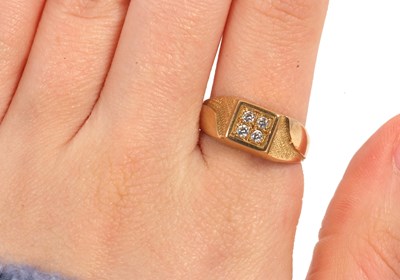 Lot 6 - A gentleman's dress ring, the central squared...