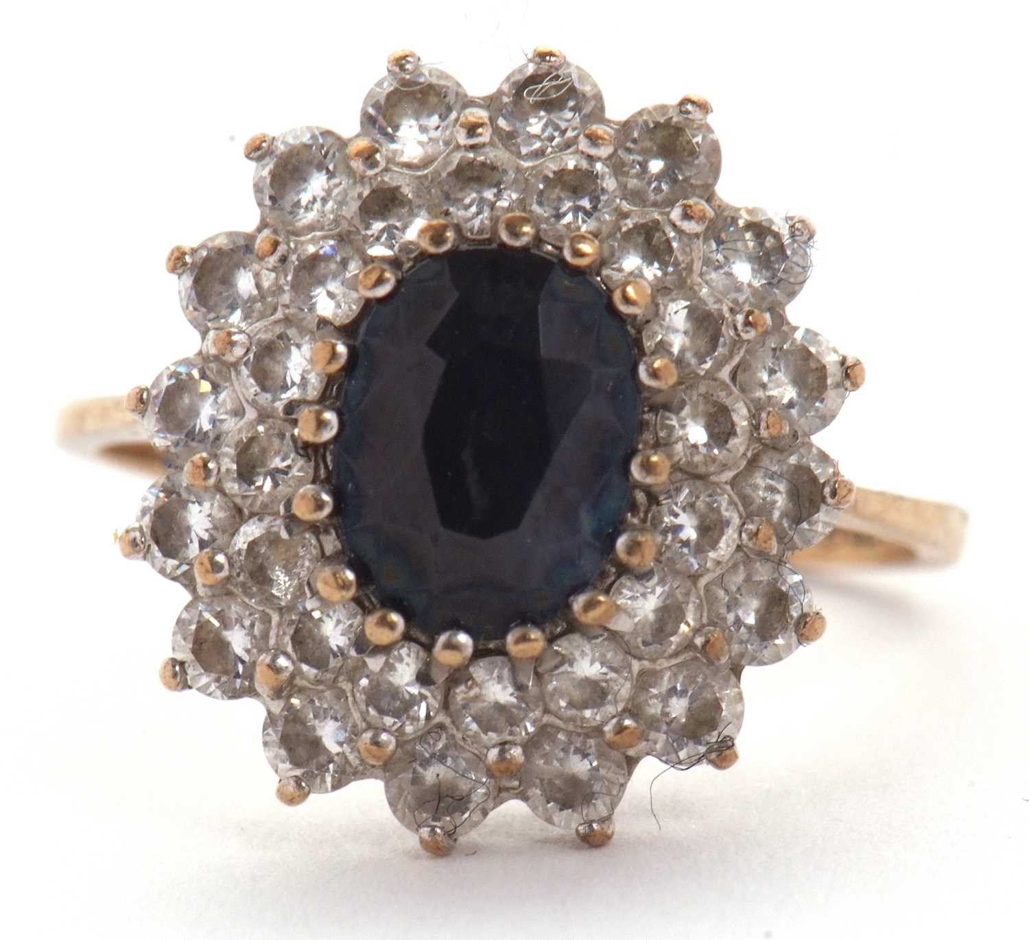 Lot 10 - A 9ct sapphire cluster ring, the central oval...