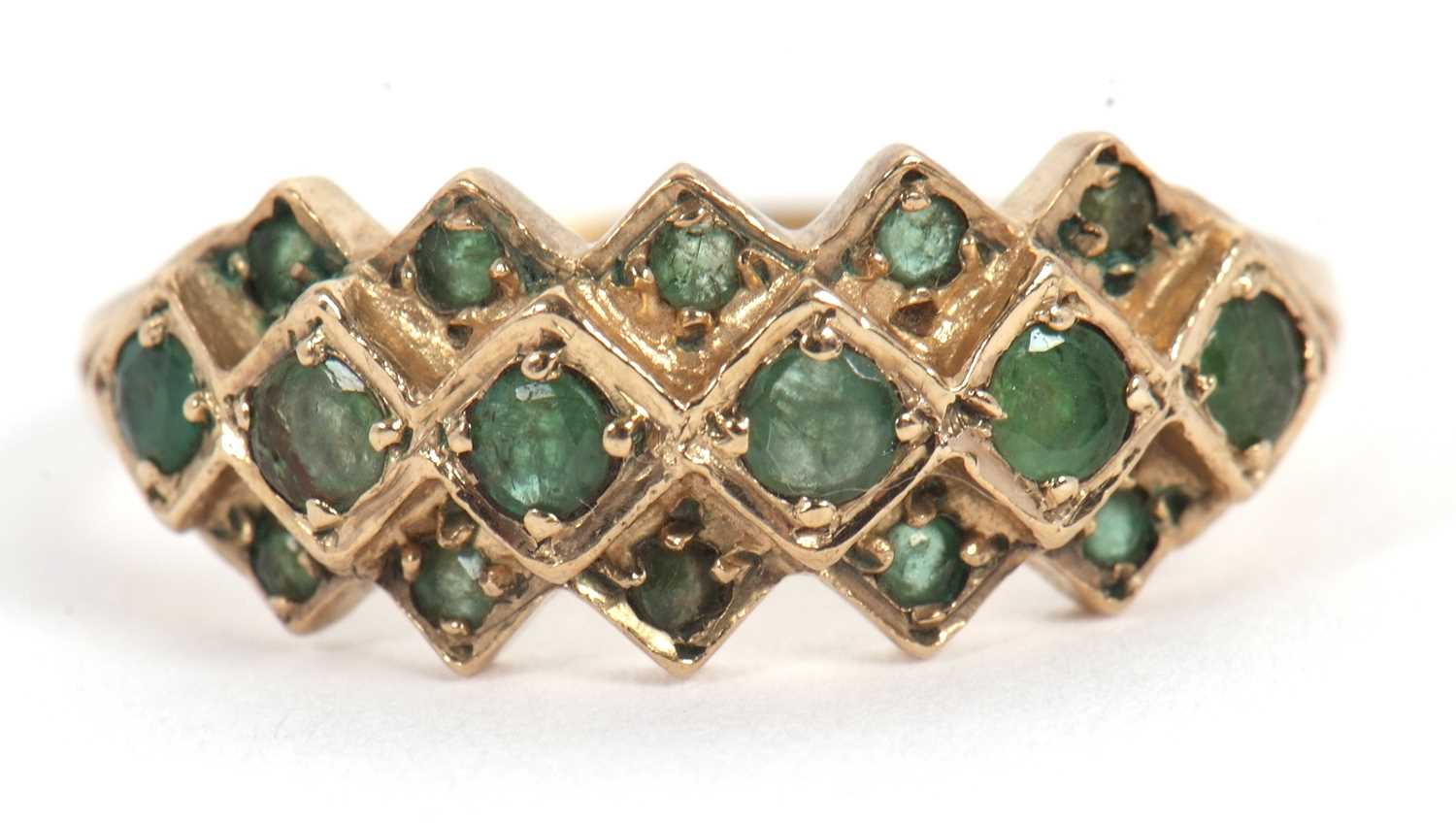 Lot 36 - A 9ct emerald ring, set with a central row of...