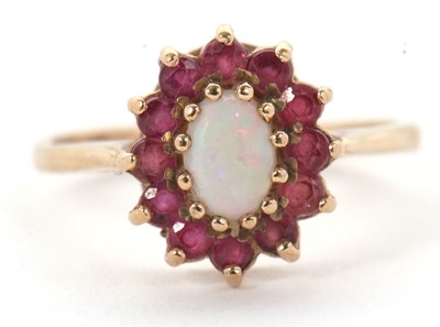 Lot 46 - A 9ct opal and ruby ring, the central oval...