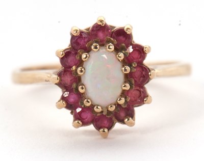 Lot 46 - A 9ct opal and ruby ring, the central oval...