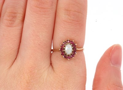 Lot 46 - A 9ct opal and ruby ring, the central oval...