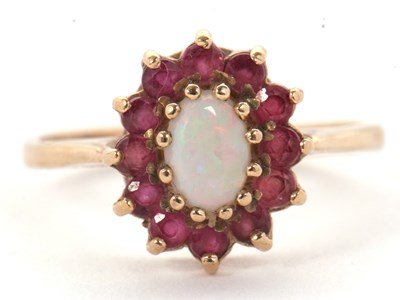 Lot 46 - A 9ct opal and ruby ring, the central oval...