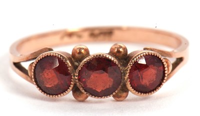 Lot 49 - A rose gold garnet ring, the three round...