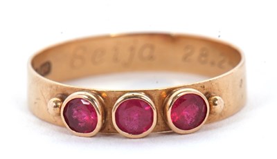 Lot 57 - A three stone ruby ring, the three round...