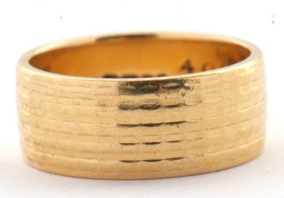 Lot 194 - An 18ct ring, with textured all around design,...