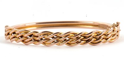 Lot 123 - A gold bangle, the hinged bangle with plaited...