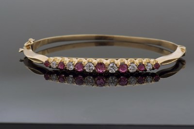 Lot 323 - 18ct gold ruby and diamond hinged bracelet,...