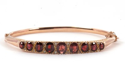 Lot 146 - A 9ct garnet and diamond bangle, the upper...