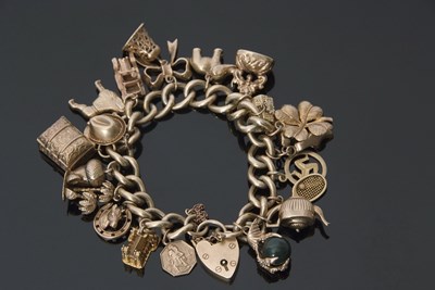 Lot 337 - 9ct gold curb link bracelet suspending various...
