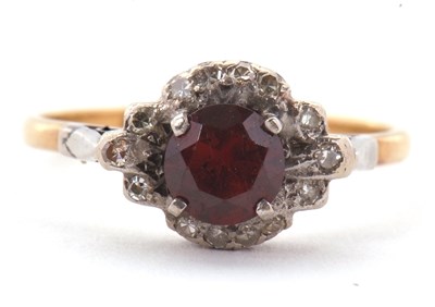 Lot 21 - A garnet and diamond ring, the central round...