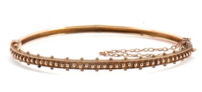 Lot 119 - A 9ct Etruscan revival bangle, the upper half...