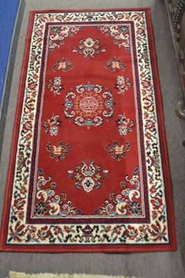 Lot 557 - A modern Chinese red ground floor rug with...