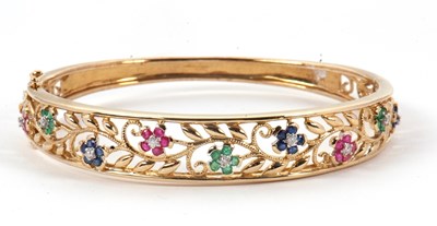 Lot 143 - A 9ct multi gemset bangle, the hinged bangle...