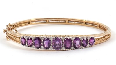 Lot 144 - A 9ct amethyst and diamond bangle, the upper...