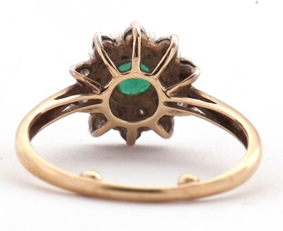 Lot 22 - An emerald and diamond cluster ring, set with...