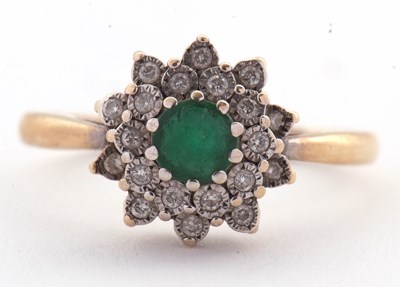 Lot 22 - An emerald and diamond cluster ring, set with...
