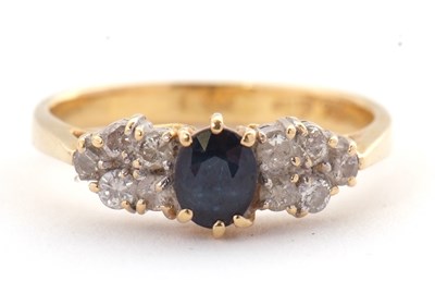 Lot 11 - An 18ct sapphire and diamond ring, the central...