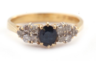 Lot 11 - An 18ct sapphire and diamond ring, the central...