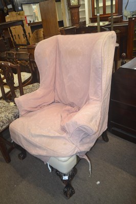 Lot 570 - A Georgian Revival wing back armchair raised...