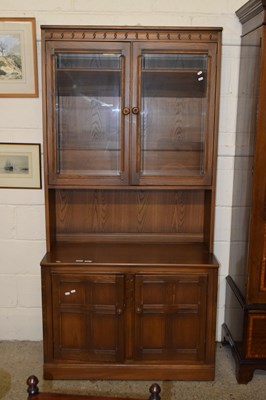 Lot 264 - An Ercol medium elm display cabinet with...