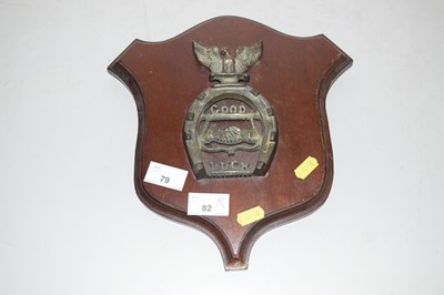 Lot 79 - Brass wall plaque marked Good Luck set on a...