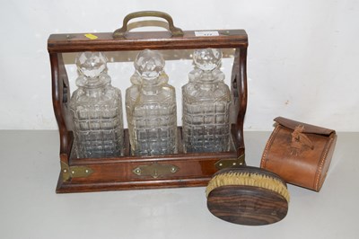Lot 177 - An oak tantalus with three glass decanters