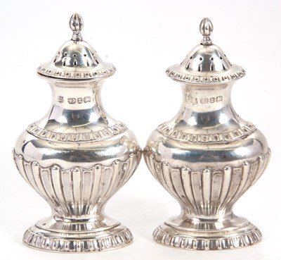 Lot 19 - A pair of Victorian silver peppers of urn form...