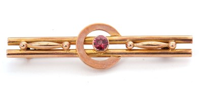Lot 118 - A garnet bar brooch, with central round garnet...