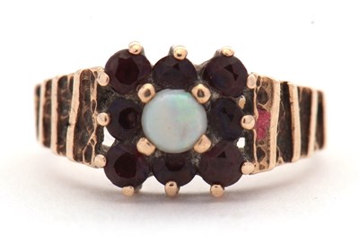 Lot 85 - A 9ct opal and garnet ring, the central round...