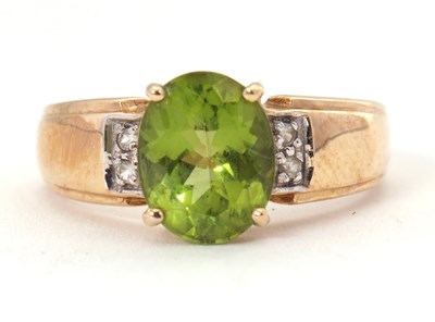 Lot 55 - A 9ct peridot and white stone ring, the oval...