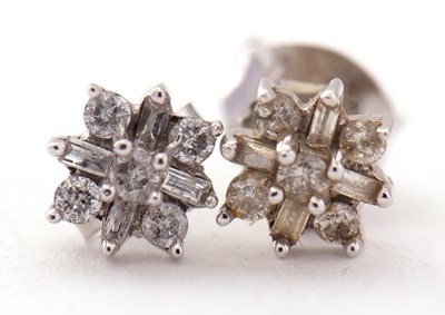 Lot 93 - A pair of 9K white gold diamond earrings, set...