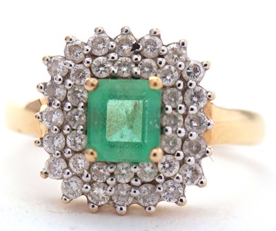Lot 65 - An 18ct emerald and diamond cluster ring, the...