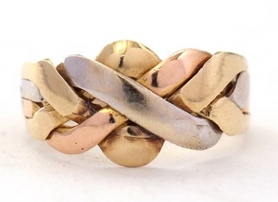 Lot 35 - A tri-colour precious metal puzzle ring, the...