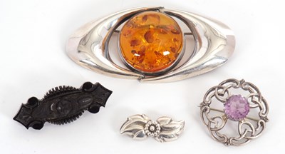 Lot 246 - Four brooches: to include an amber brooch,...