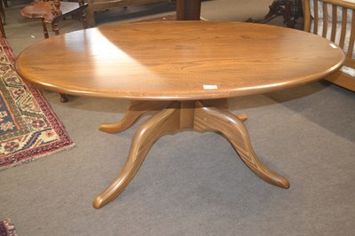 Lot 680 - An Ercol elm oval coffee table supported on...