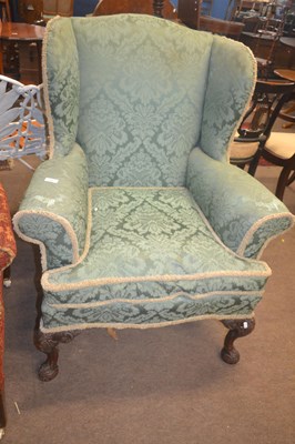 Lot 548 - A Georgian Revival wing back armchair raised...